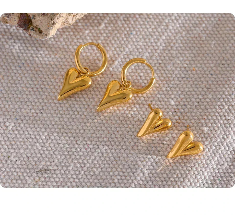 18K gold-plated heart-shaped earrings set on textured fabric background