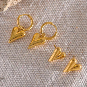 18K gold-plated heart-shaped earrings set on textured fabric background