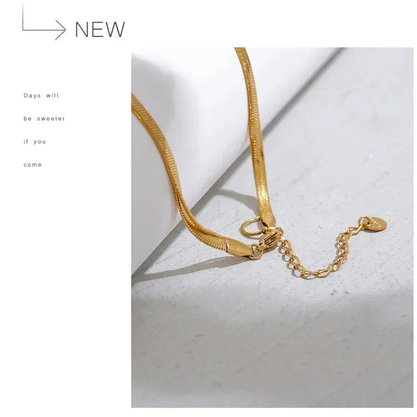 Gold necklace on a light gray background with text overlay