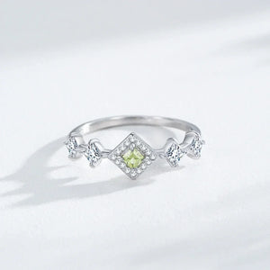 Silver ring with a green gemstone on a light gray background-TM & CO. JEWELS 