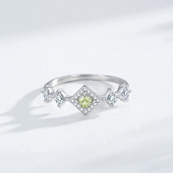 Silver ring with a green gemstone on a light gray background-TM & CO. JEWELS 