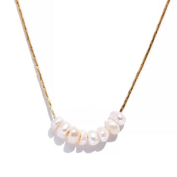 Gold-plated chain necklace with seven white freshwater pearls on white background
