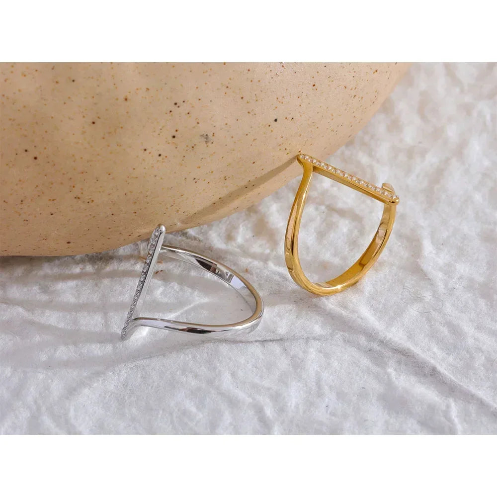 Silver and gold-plated geometric rings with pavé accents on textured white fabric