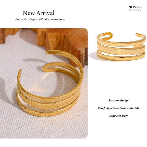 Gold cuff bracelet on a textured surface with 'NEW++' branding.