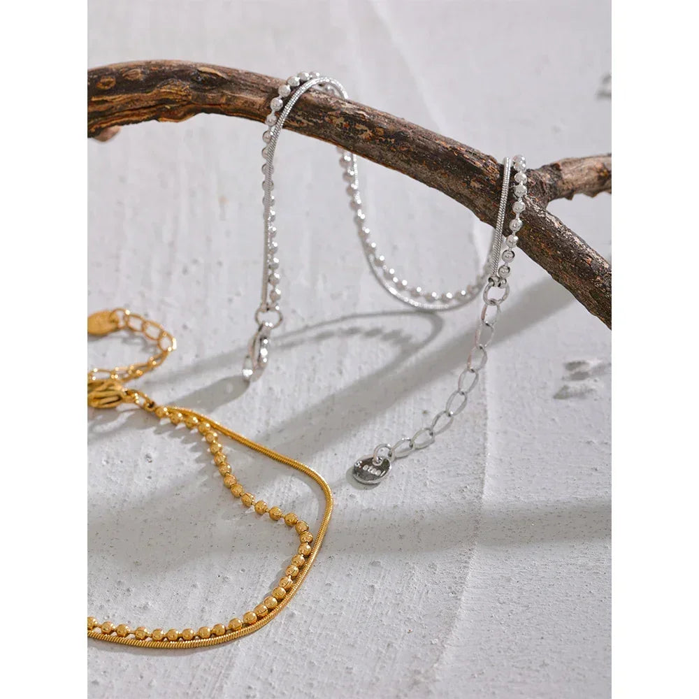 18K gold-plated and 925 silver beaded chain bracelets displayed on a branch