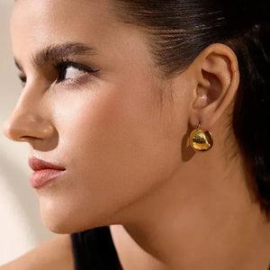 Woman wearing elegant round 18K gold-plated dangle earrings, close-up view