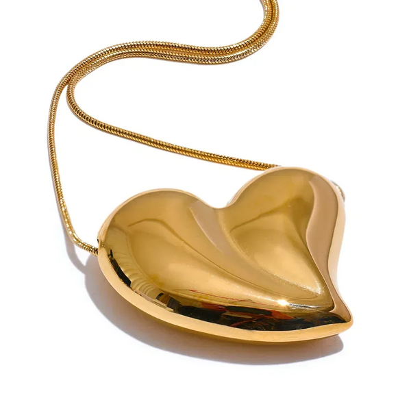 Gold heart-shaped clutch with a chain on a white background