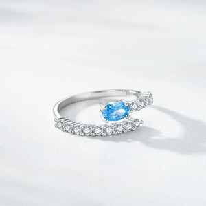 Silver ring with a blue gemstone on a white background