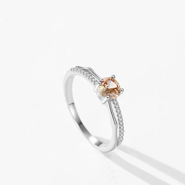 Silver ring with a peach-colored gemstone on a white background