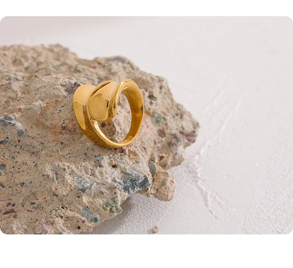 18K gold-plated knot design ring on textured stone, minimalist jewelry style