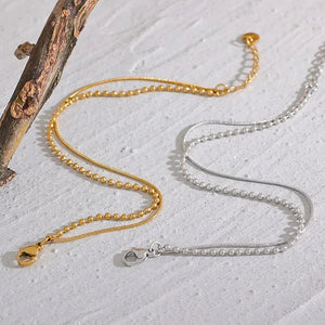 Gold-plated and silver 925 beaded chain necklaces with clasps on textured white surface