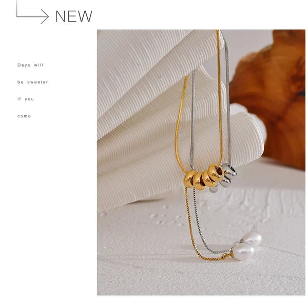 Gold and silver earrings with pearls on a textured surface