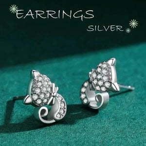 Silver earrings with gemstones on a green surface