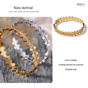 Two gold and silver bangles on a textured surface with 'NEW++' branding.