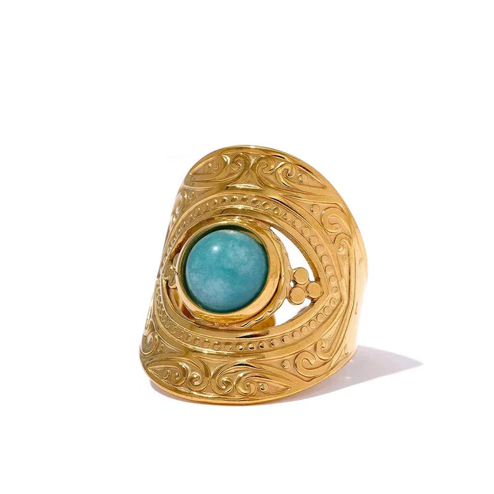 Gold ring with turquoise stone on a white background