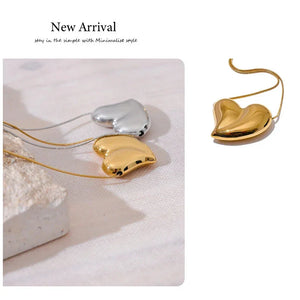 Heart-shaped gold and silver earrings on a light background