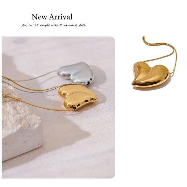 Heart-shaped gold and silver earrings on a light background