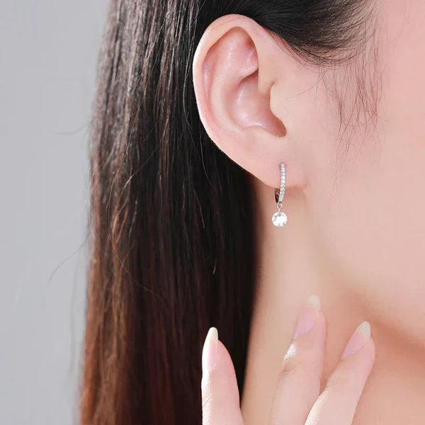 Close-up of an earring worn by a person with dark hair.