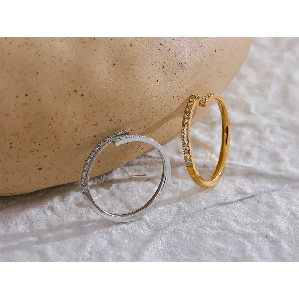 Gold and silver open rings with small crystals, minimalist jewelry on textured fabric