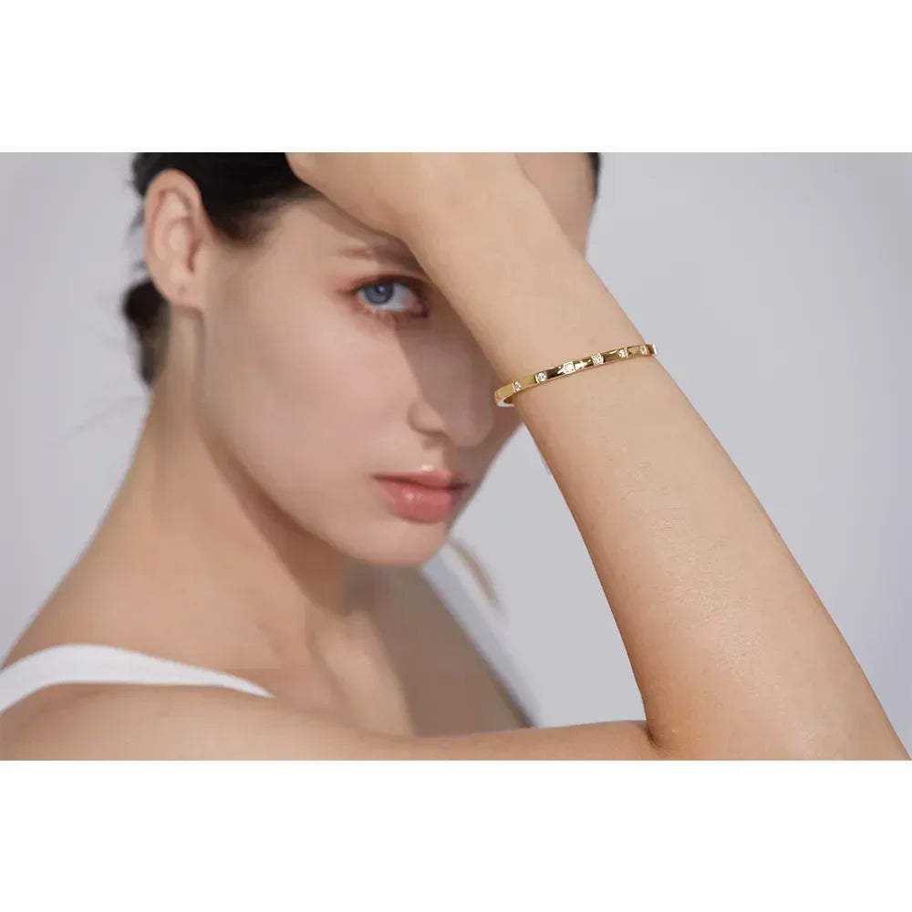 Woman wearing a minimalist 18K gold-plated textured bracelet on her wrist