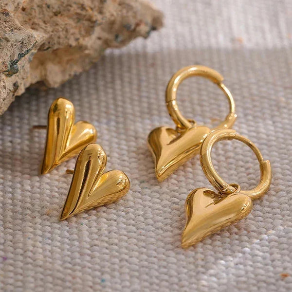 Gold heart-shaped earrings on a textured surface with 'HAPPY EVERYDAY' branding.