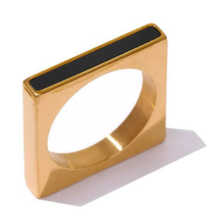 Gold ring with black accent on a white background