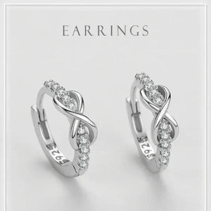 Pair of silver earrings with clear stones on a light gray background