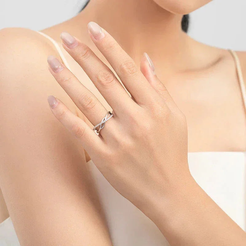 Woman wearing a silver infinity knot ring on hand, minimalist jewelry style