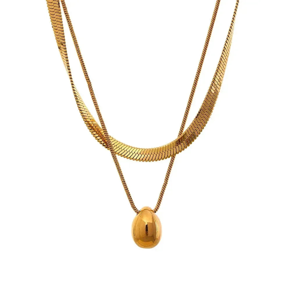Layered 18K gold-plated necklace with herringbone chain and polished oval pendant on white background