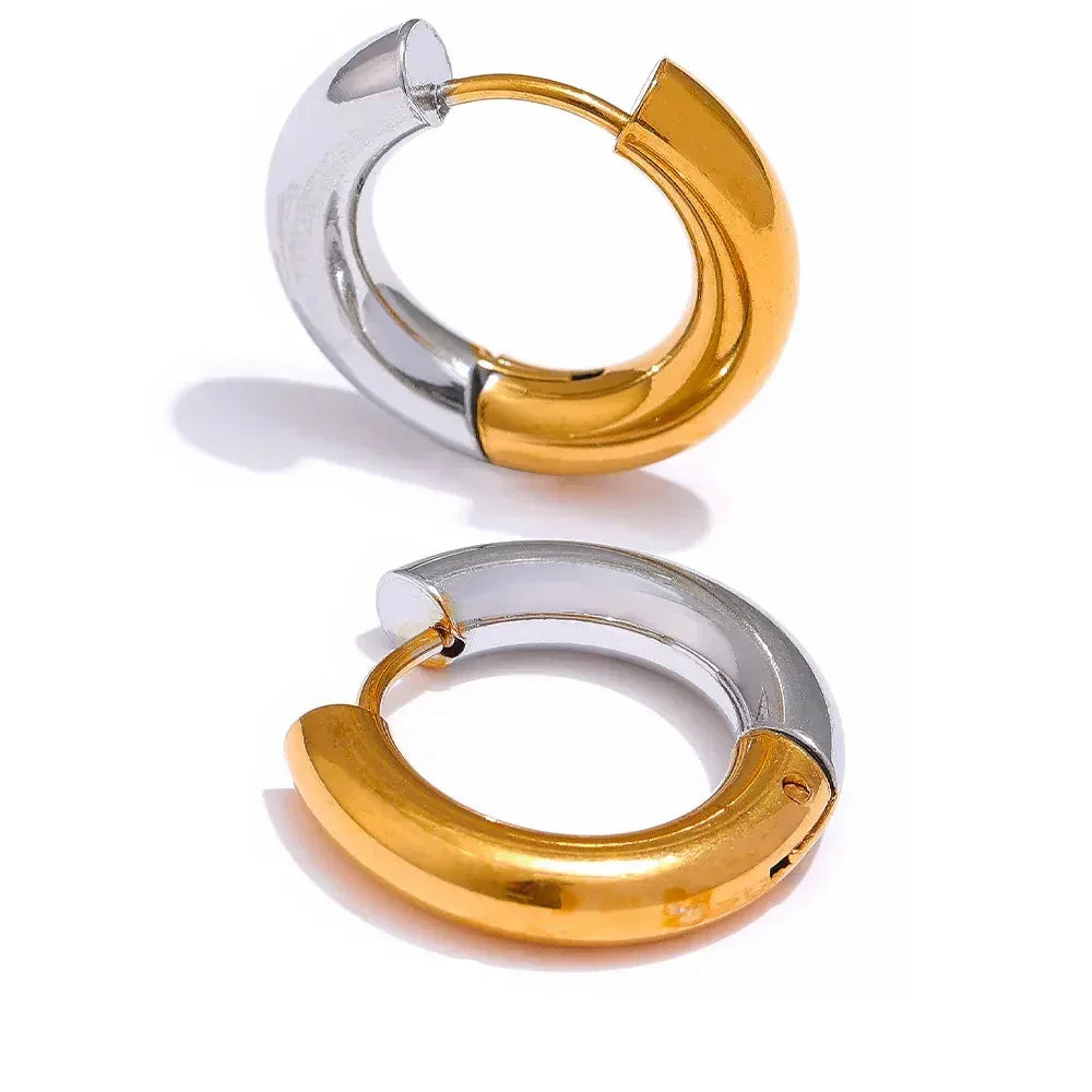 Pair of chunky hoop earrings in two-tone gold and silver on white background
