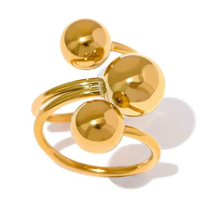 Gold ring with spherical elements on a white background