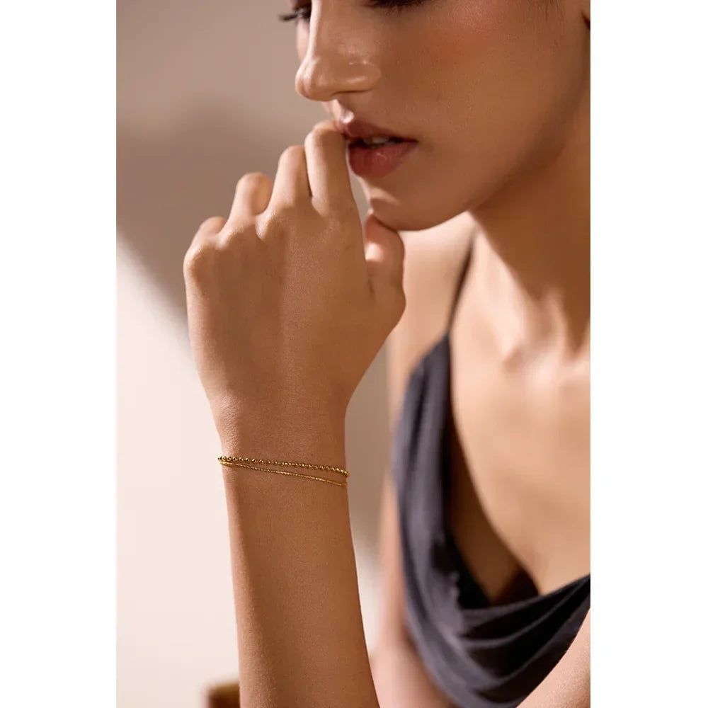 Woman wearing a delicate 18K gold-plated bracelet, elegant jewelry for women