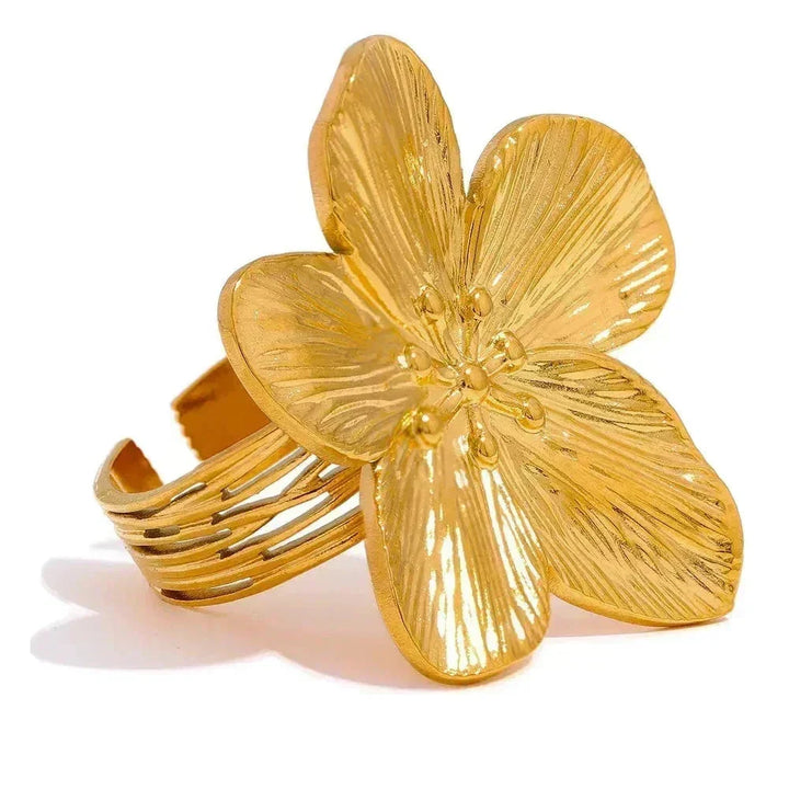 Gold flower-shaped cuff bracelet on a white background