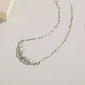 Silver necklace on a light gray background