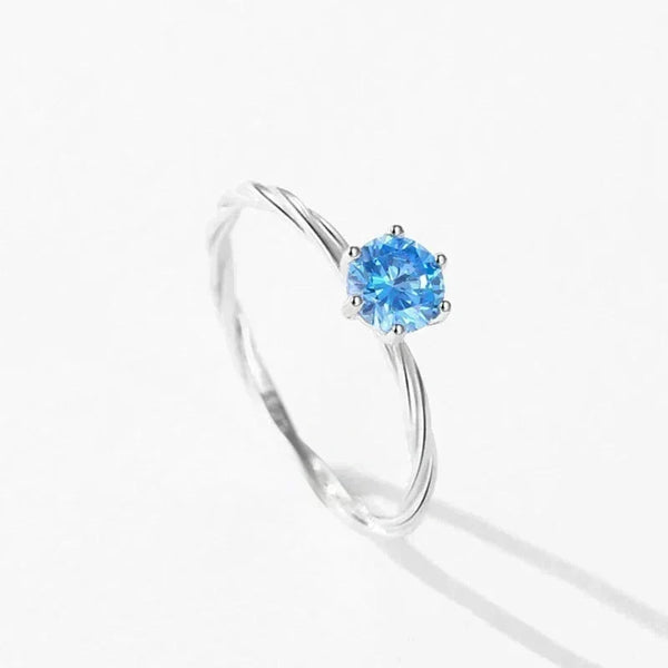 Silver ring with a blue gemstone on a white background
