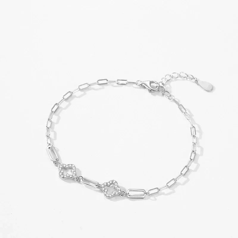 Sterling silver bracelet with chain links and two diamond-shaped charms on white background