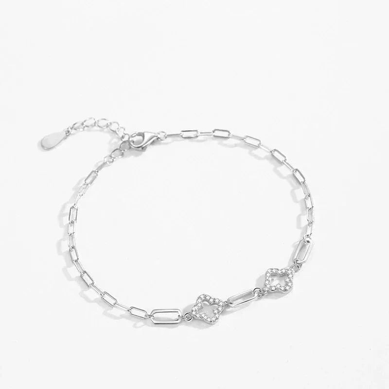 925 silver chain bracelet with geometric links and two heart-shaped pavé accents on white background