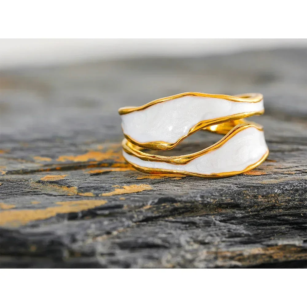 18K gold-plated white enamel wavy ring on textured stone surface