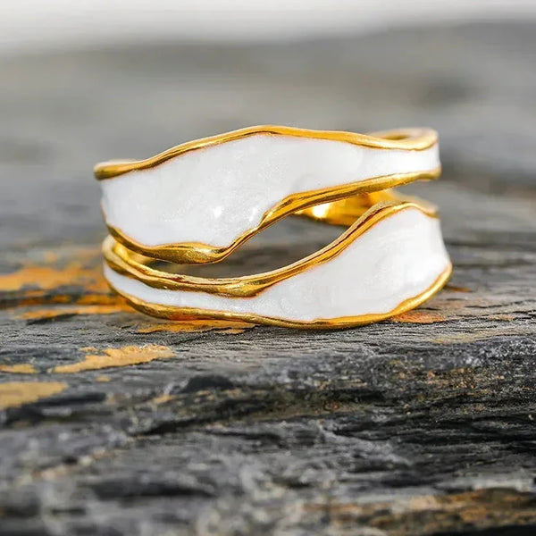 18K gold-plated white enamel wavy ring on textured stone surface