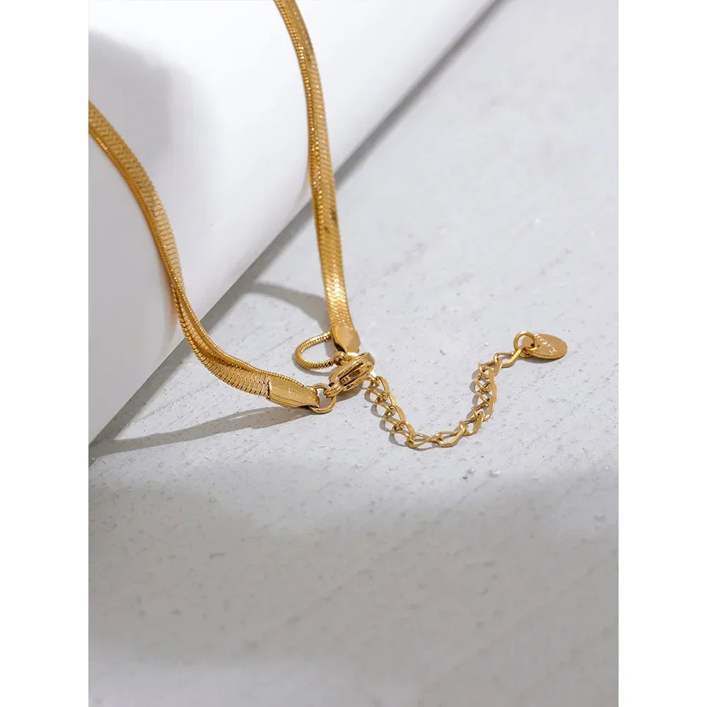18K gold-plated flat chain necklace with adjustable clasp on light surface