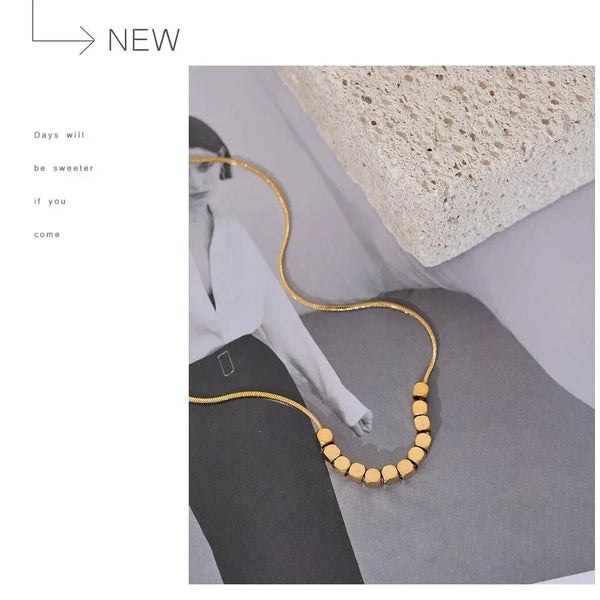 Gold necklace on a gray surface with a minimalistic background