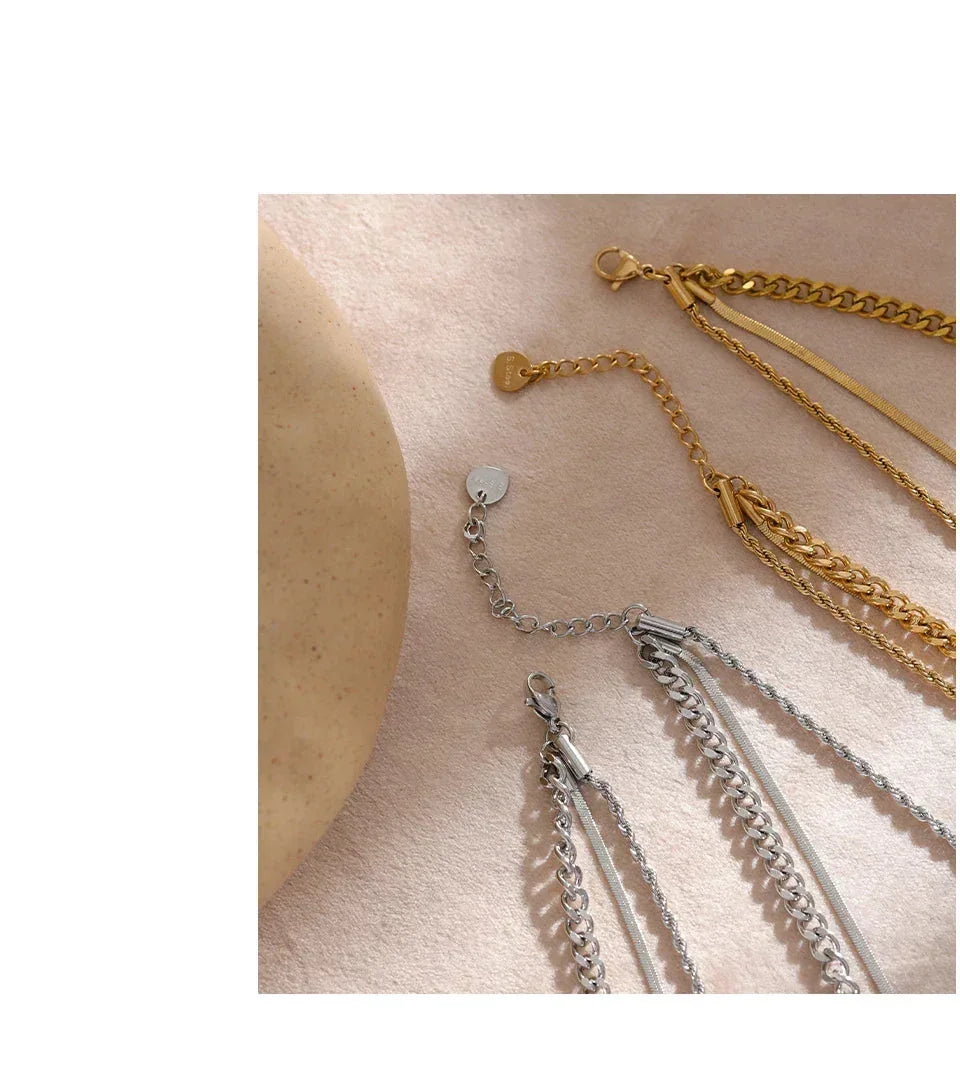 Gold and silver chain necklaces on a soft beige background, minimalist jewelry display