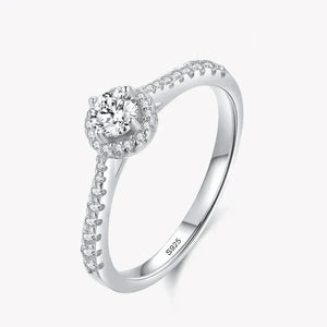 Sterling silver ring with round center cubic zirconia and pavé band on white background