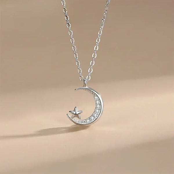 Silver necklace with a crescent moon and star pendant on a beige background-Moonlit Star Pendant - TM & Co. Jewels.