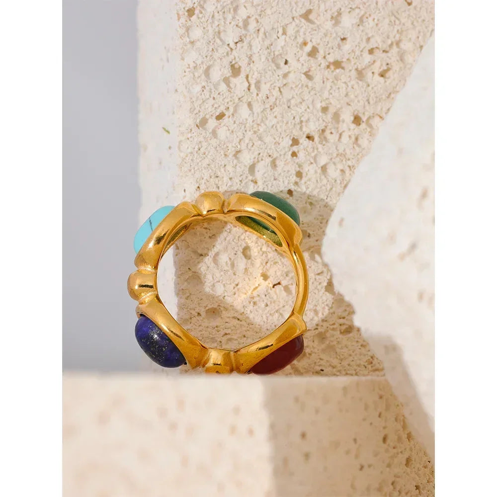 18K gold-plated ring with colorful gemstone cabochons on textured stone background