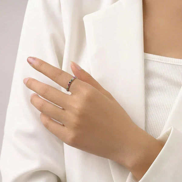 Hand wearingPrism Luxe Stackable Ring - TM & Co. Jewels-Silver ring with multicolored gemstones on a white background.