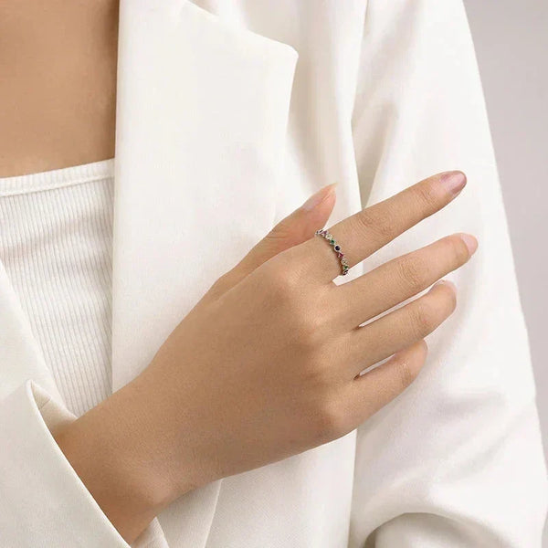 Hand wearing Prism Luxe Stackable Ring - TM & Co. Jewels-Silver ring with multicolored gemstones on a white background. 