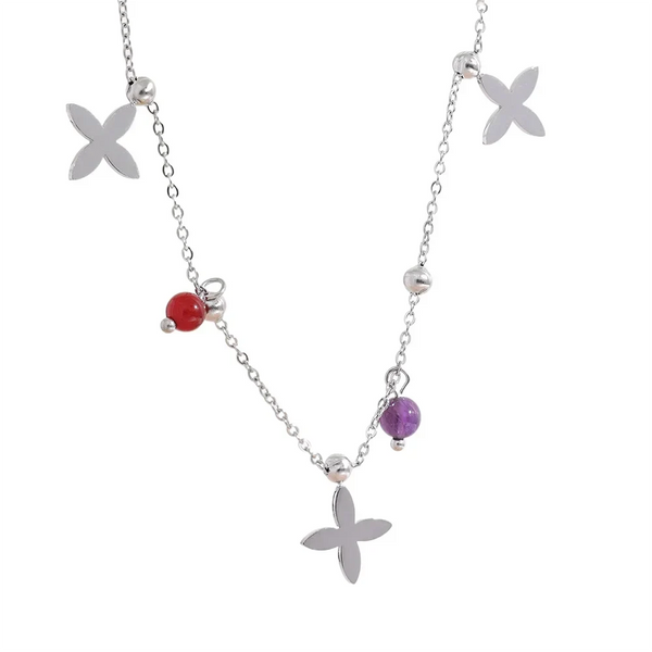 Necklace with floral pendants and red and purple beads on a white background