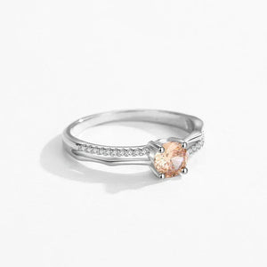 Silver ring with a peach-colored gemstone on a white background