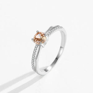Silver ring with a peach-colored gemstone on a white background